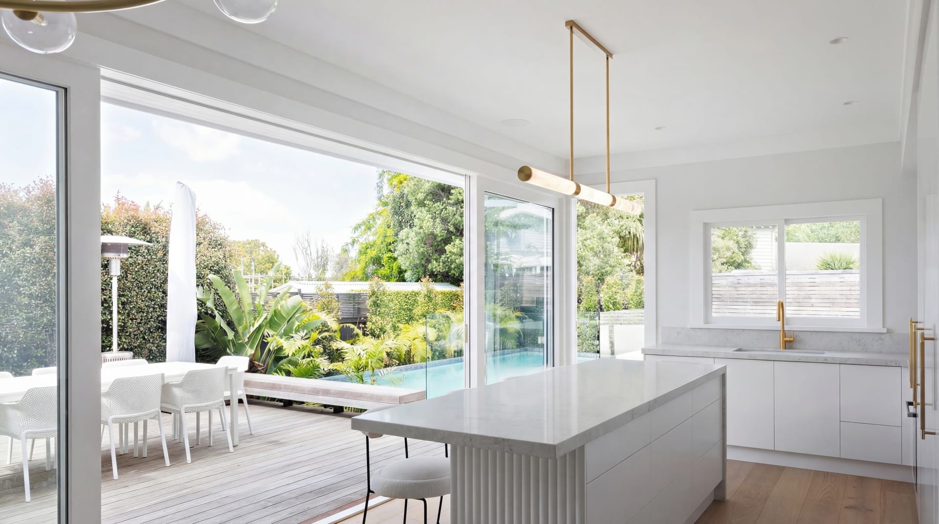 Modern open-plan kitchen and dining opening to pool and garden — Wrightson Construction
